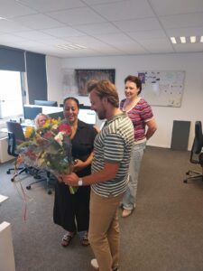 Jobcoach Rob Hendriks overhandigt Sharon een bos bloemen bij het tekenen van haar contract